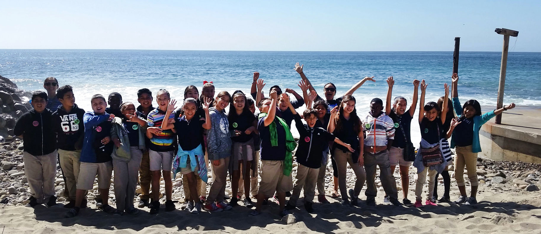 Group of young kids on the beach by ocean